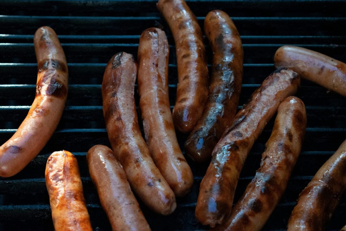 Grilled sausage on black grill.