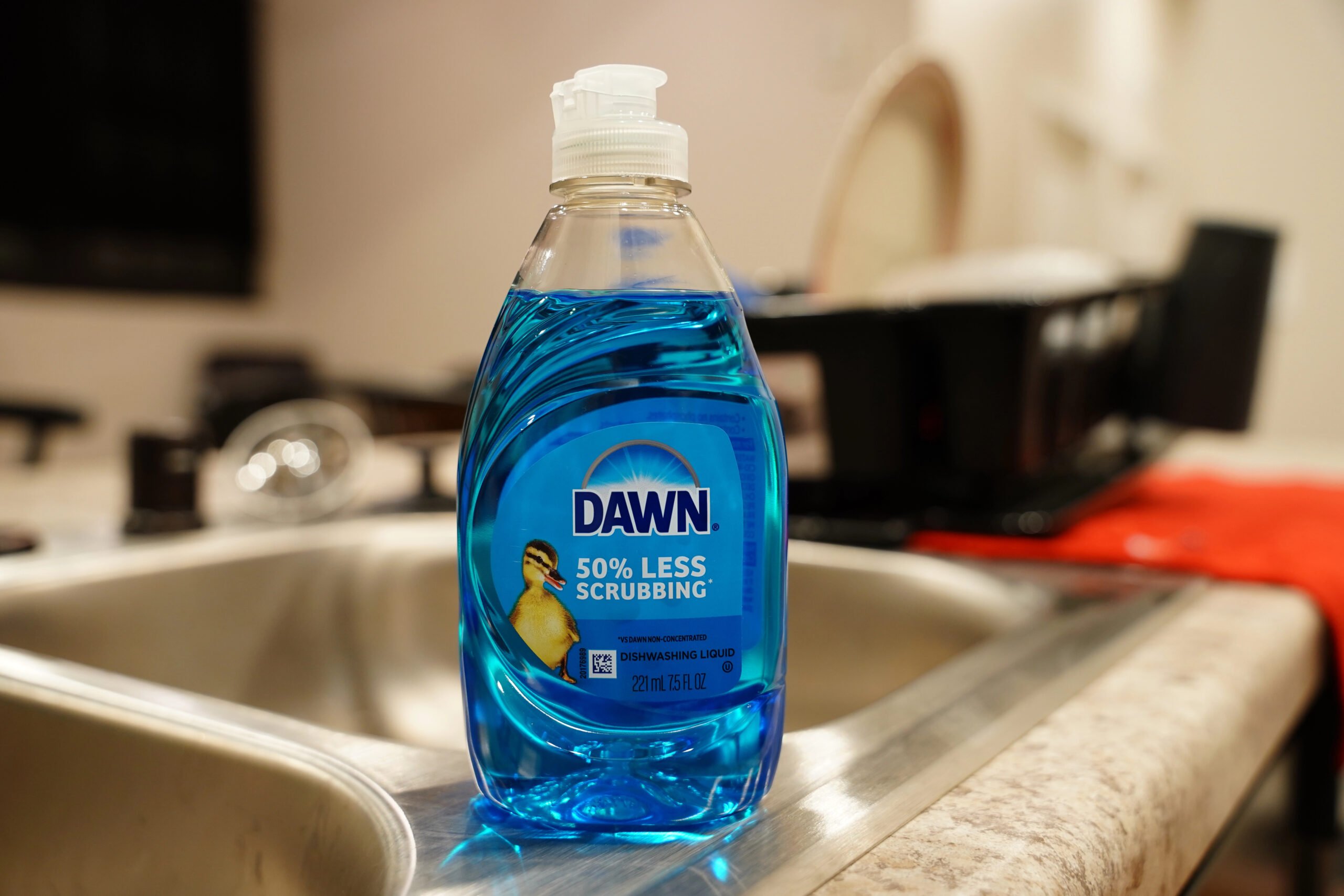 Blue bottle of Dawn dish detergent soap sits on a sink.