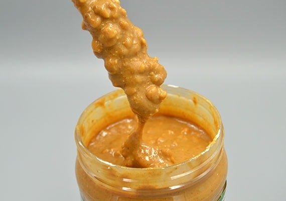 Close up photo showing the chunks of peanut in Teddie super crunchy natural peanut butter