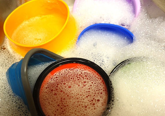 Collapsible silicone dog bowls washed in soapy water in sink