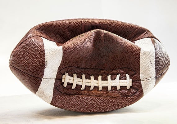 Deflated football that was punctured by sharp dog teeth
