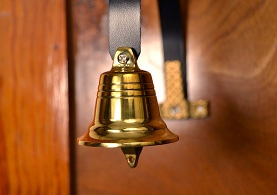 GoGo Bell Deluxe Dog Doorbell attached to wooden wall