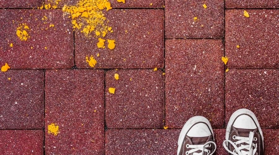 Goldfish crackers on ground crushed up next to shoes