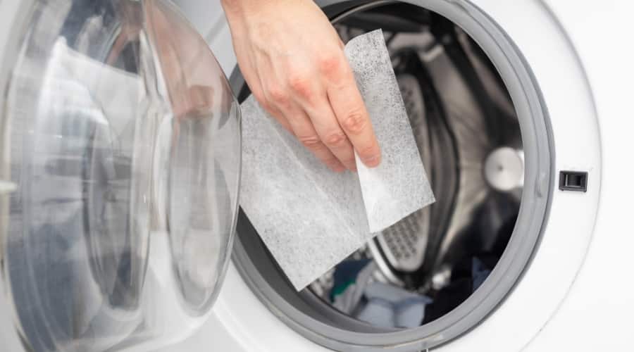 Hand Putting Dryer Sheet in Dryer