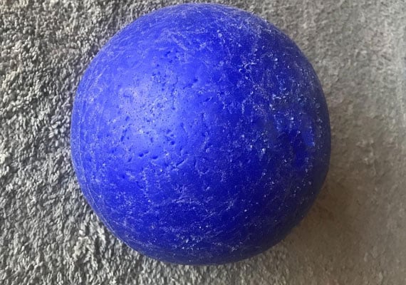 Hard plastic soccer ball with chews and scratches from dog
