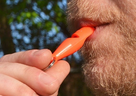 Man blowing on Acme 212 dog training whistle.