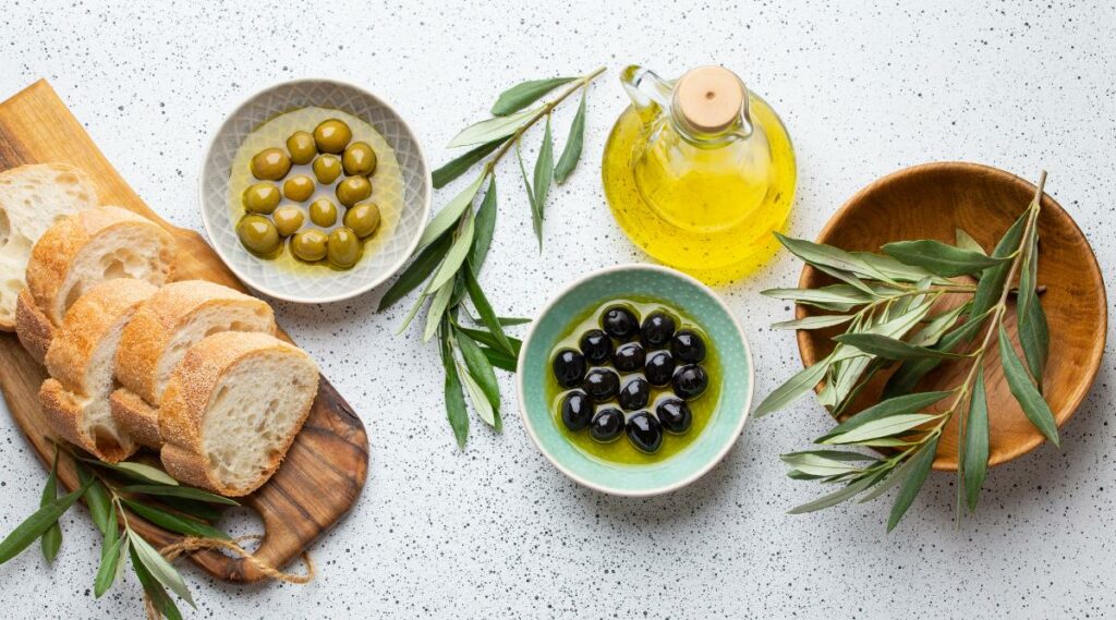 Olive oil and olives on table
