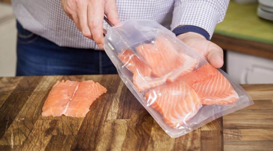 Person pulling raw salmon out of bag