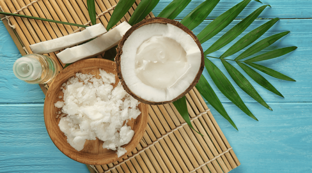 Plate with fresh coconut oil and half of nut on wooden table