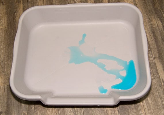 PuppyGoHere Litter Pan holding leaked urine from a dog pee pad simulation