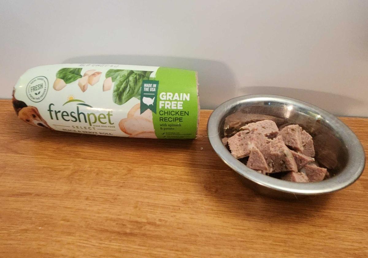 Sliced up Freshpet select chicken dog food in a bowl next to a tube.