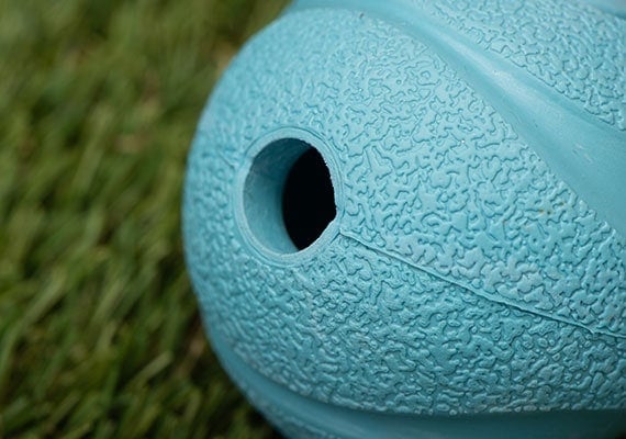Small hole in side of dog tennis ball that whistles when thrown