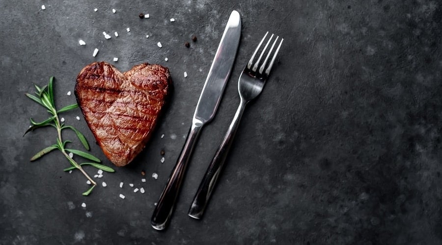 Steak in heart shape with salt.