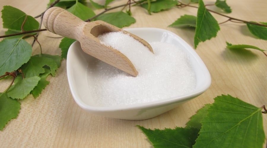 Bowl of sugar with scoop.