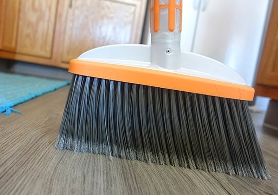 Sweeping dog hair up off kitchen floor