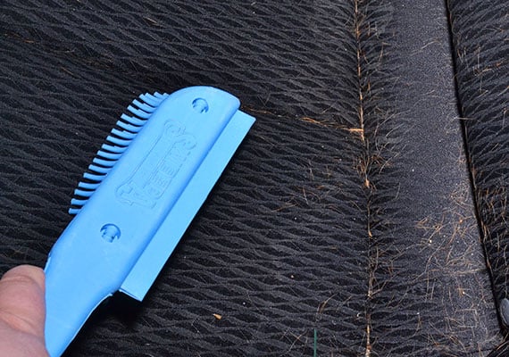 Sweeping rear car seat upholstery with sweepa rubber brush collecting built up dog hair
