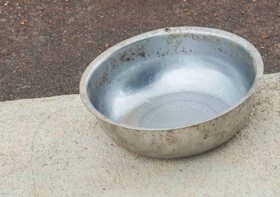 Unclean stainless steel dog bowl with food caked on sides