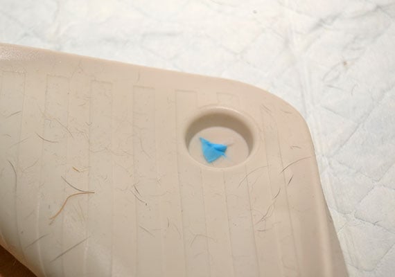 Underside of Wee Wee Silicone Pad Holder covered in hair