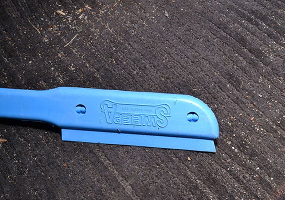 Usiong squeegee blade of Sweepa pet hair brush to remove dog hair from car carpet