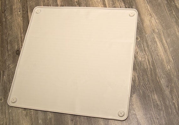 Wee Wee Silicone pee pad holder unrolled laying flat on wooden floor