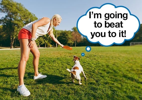 Woman throwing frisbee about to race her dog to retrieve it for exercise