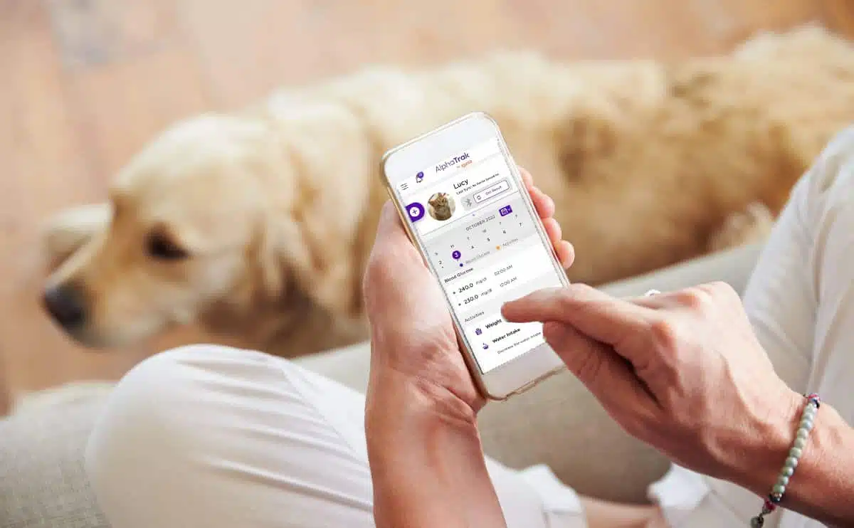 Woman with dog using AlphaTRAK 3 Pet Blood Glucose Monitoring app