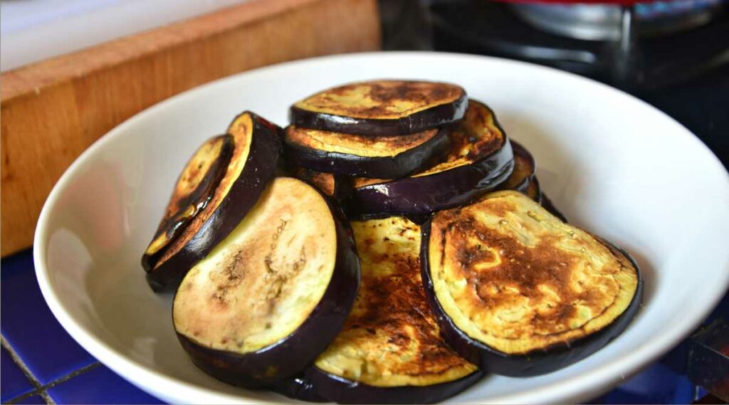 Cooked eggplant sliced in a bowl.