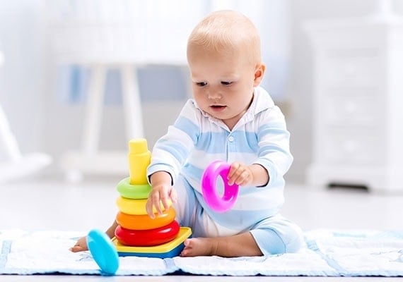 Distracted baby playing with his favorite toy