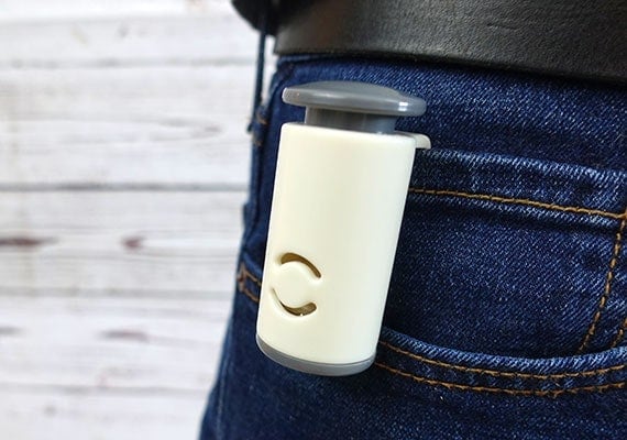 Dog training clicker hoodked on back pocked on pair of jeans held up by belt
