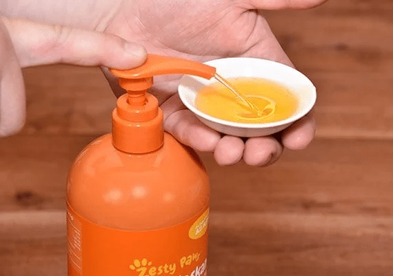 Person squirting Zesty Paws salmon oil.