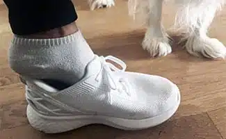 Putting on Kizik shoe hands free next to dog's paws