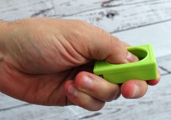 Male hand pressing loud box clicker with thumb