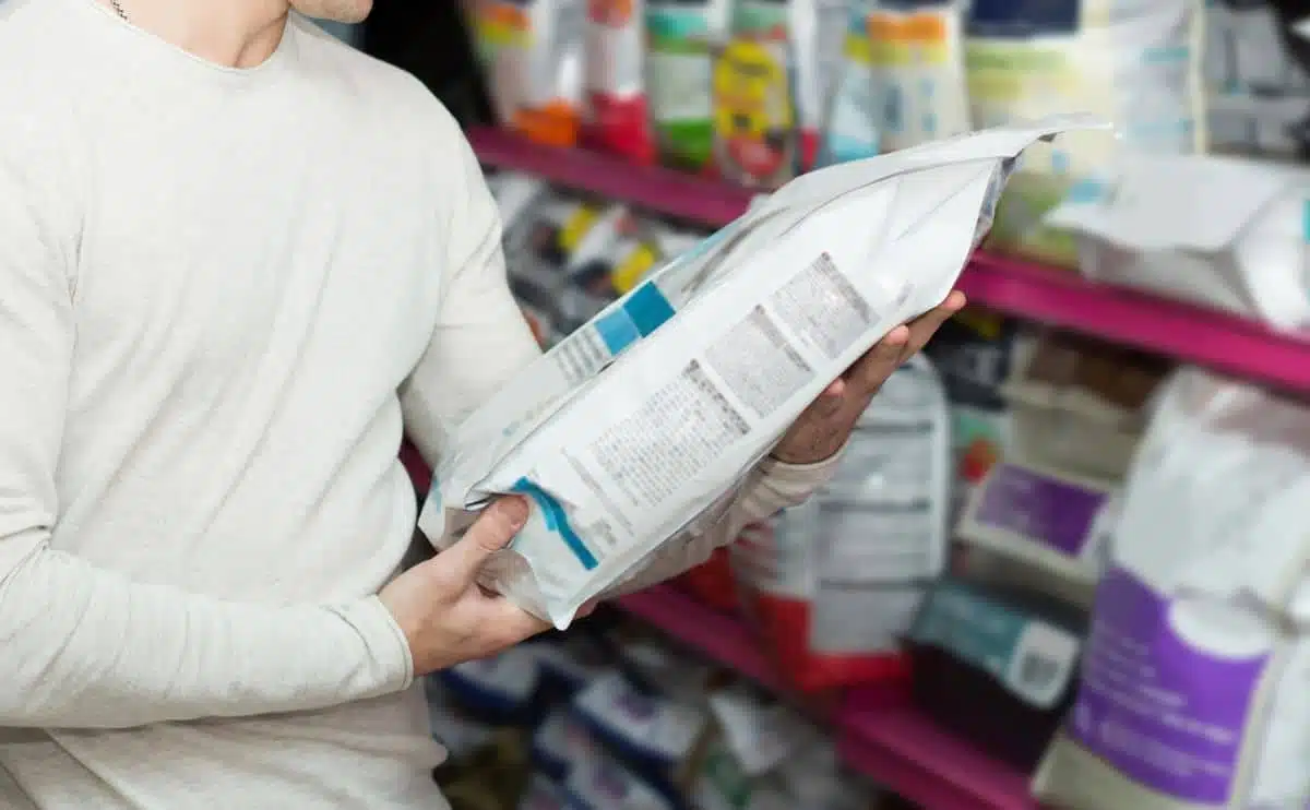 man inspecting ingredients of a dog food bag at a pet store