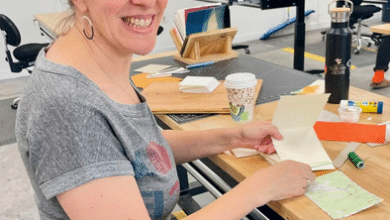 Michelle Schenker artist working and smiling at camera.