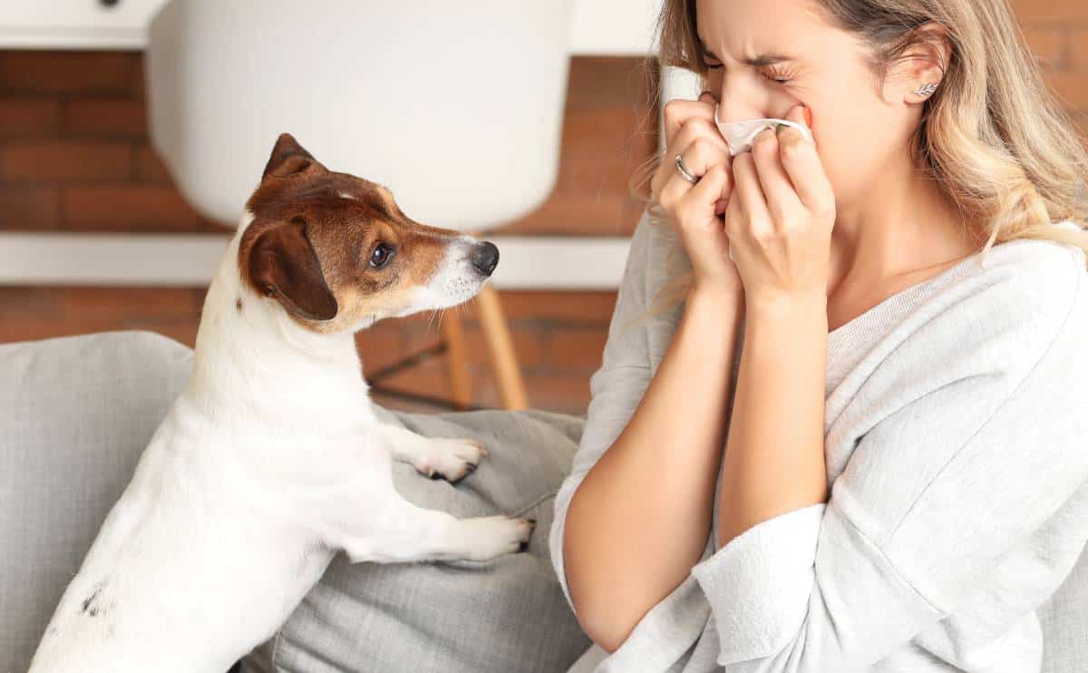 Sick woman sitting next to a dog who is not feeling well.